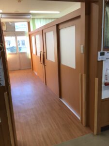 木質調の廊下・通路。引き戸と光の入る明るい空間